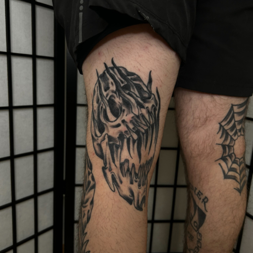 An American Traditional skull piece that boldly adorns the leg, capturing the classic essence of this iconic tattoo style. With its bold lines and timeless design, this piece stands out as a striking statement. 