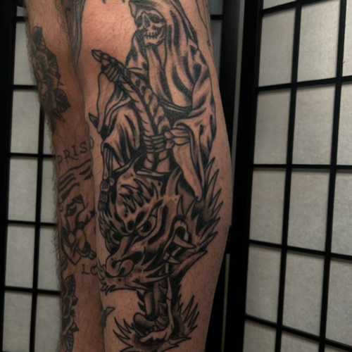 An American Traditional reaper riding a dragon on the calf, combining bold lines and vibrant colors. This design features a fierce reaper atop a majestic dragon, creating a powerful and dynamic piece that captures the essence of a classic tattoo! 