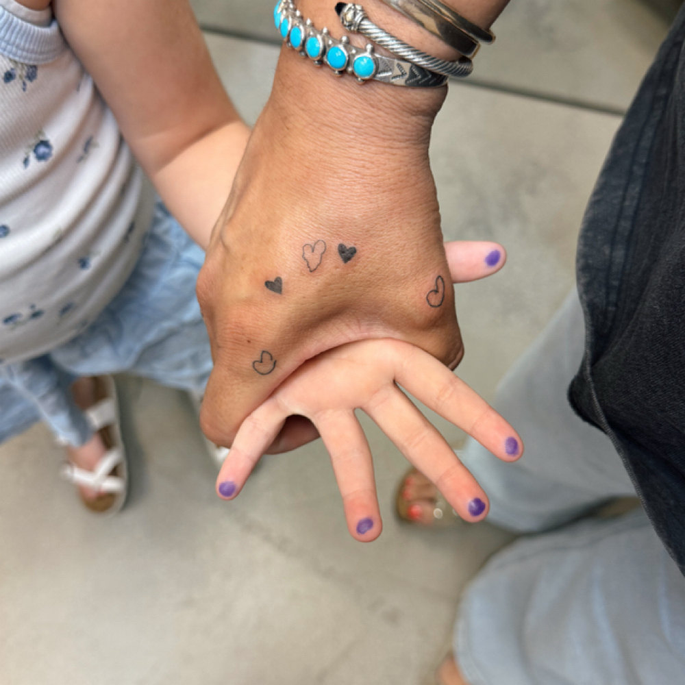 Hand Holding Tattoo at Heiress in Elk Grove, CA